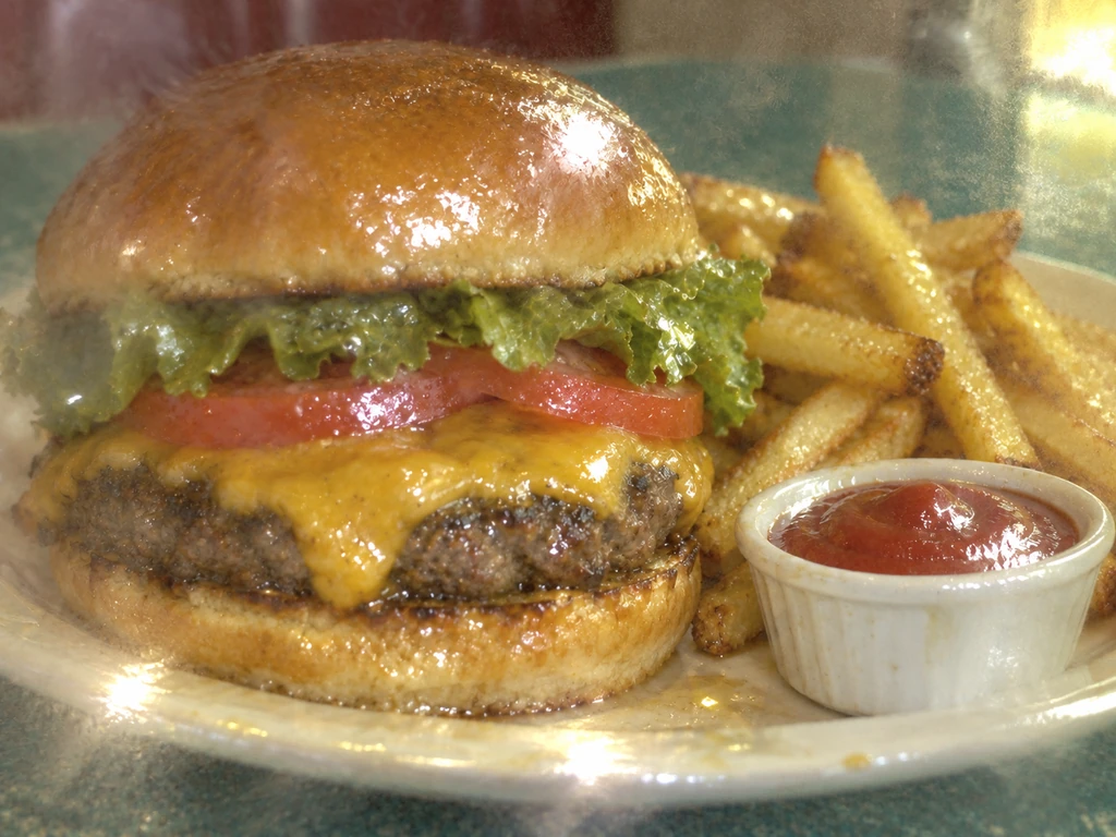 The same burger and fries looking dull, greasy, and unappetizing through a smeared lens and green-yellow lighting