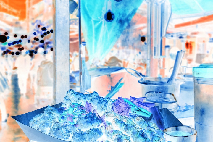 The same night-market photograph with inverted colors and cool lights